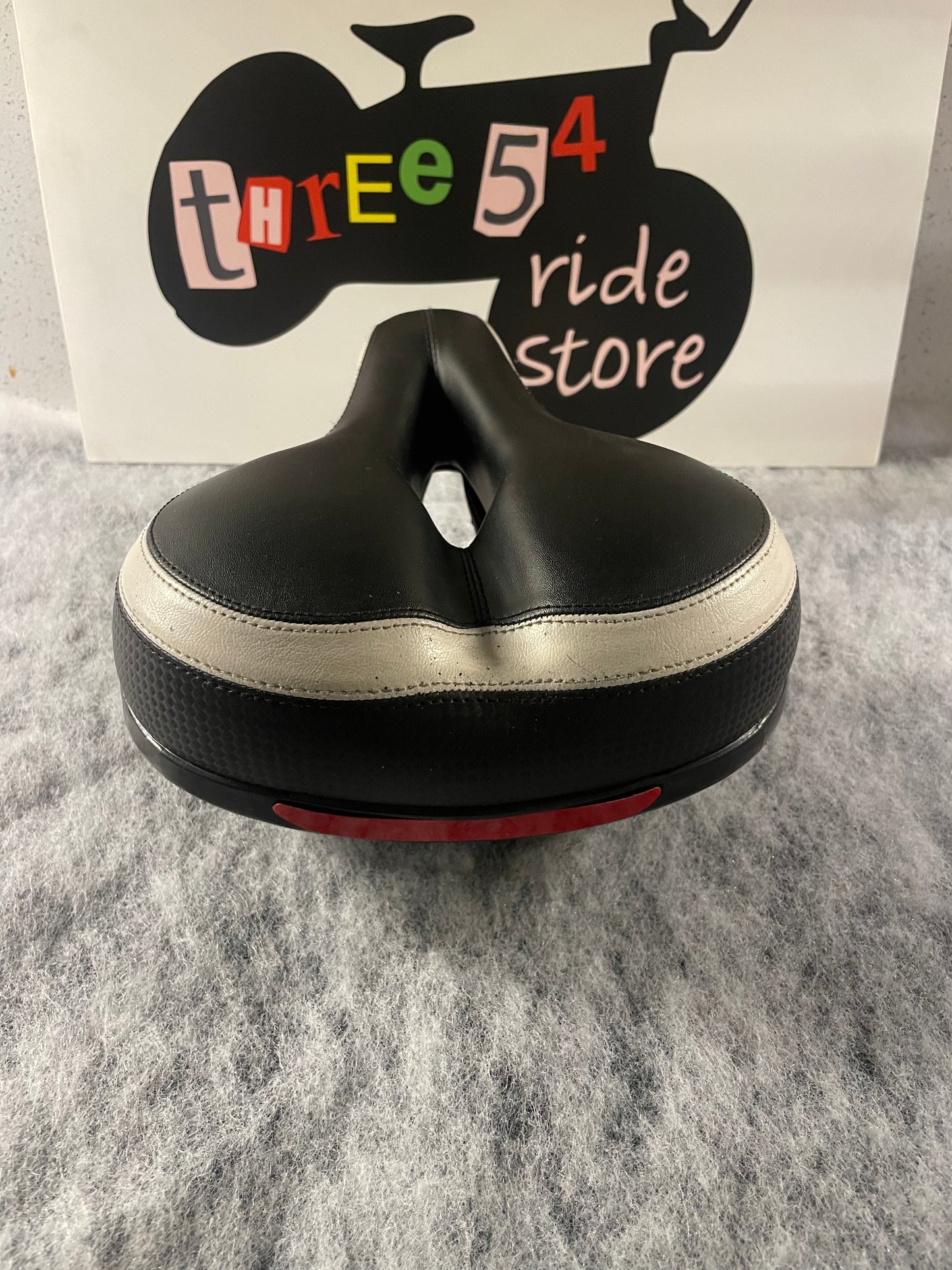Brand new wide and sprung bicycle seat for sale, black and white, built in reflector.