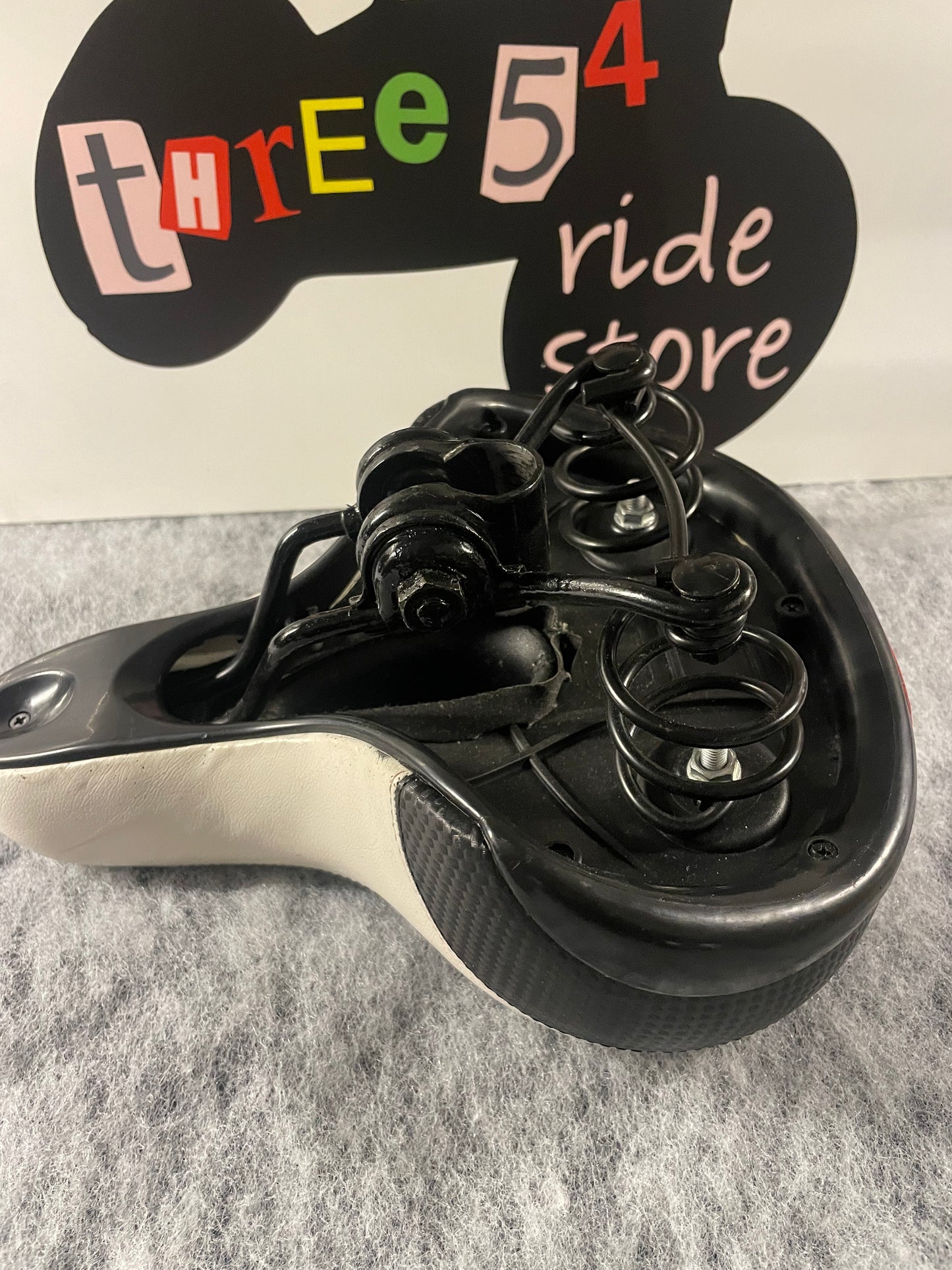 Brand new wide and sprung bicycle seat for sale, black and white, built in reflector.
