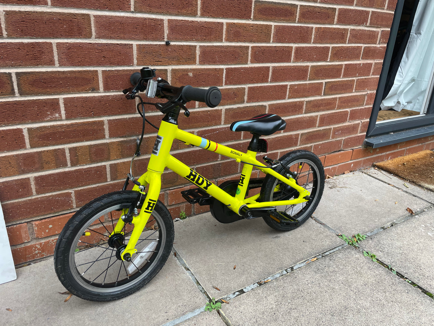 A Pre Loved Hoy Bonaly 14” first pedal bike For Sale, bright yellow, padded seat, V brakes, fully enclosed chain, nationwide delivery is available.