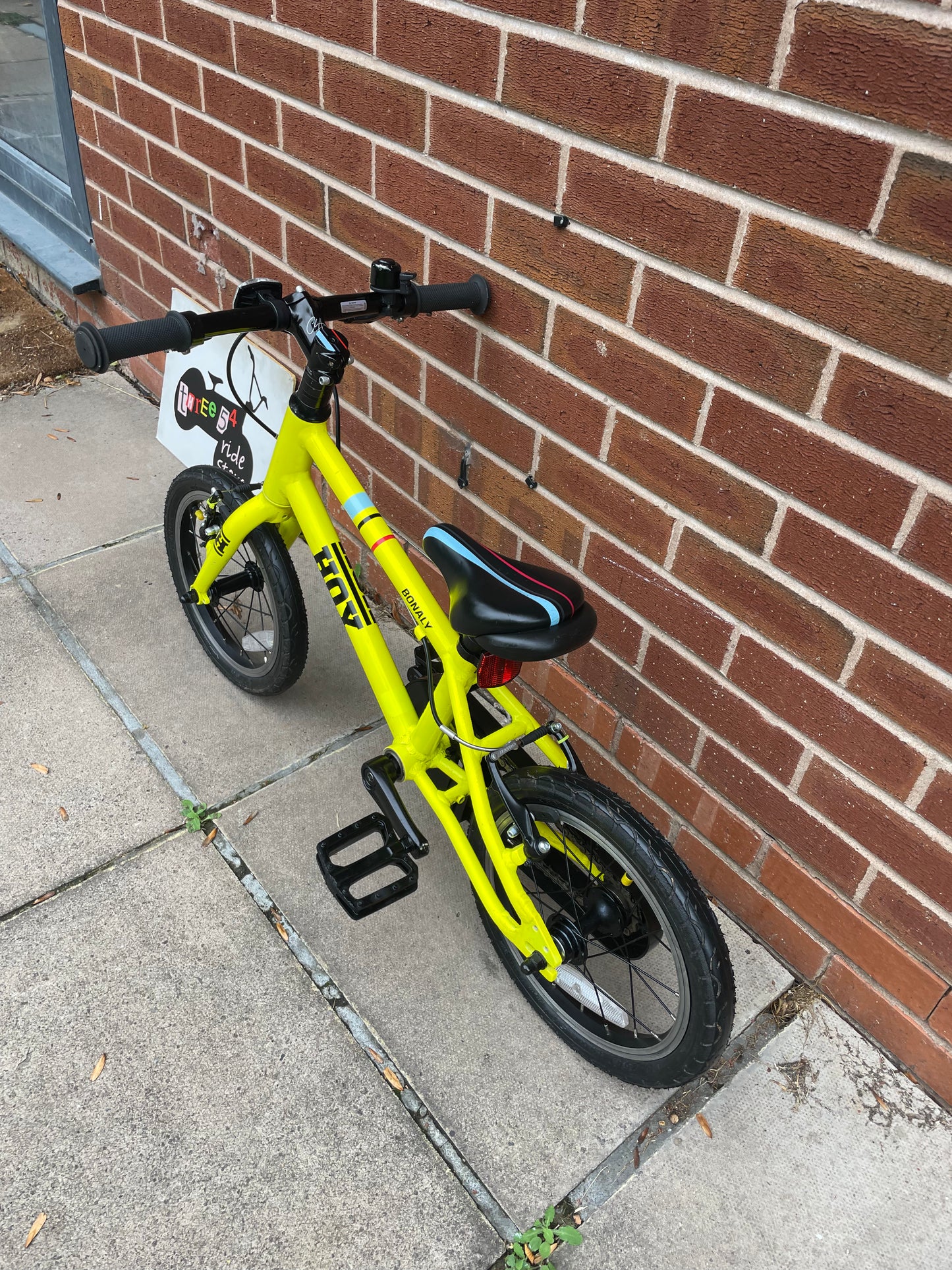 A Pre Loved Hoy Bonaly 14” first pedal bike For Sale, bright yellow, padded seat, V brakes, fully enclosed chain, nationwide delivery is available.