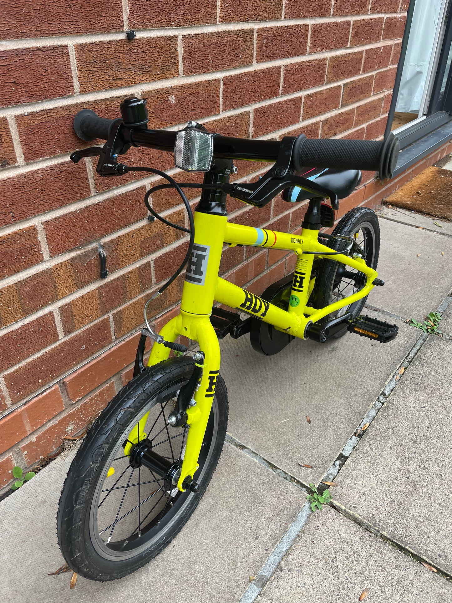 A Pre Loved Hoy Bonaly 14” first pedal bike For Sale, bright yellow, padded seat, V brakes, fully enclosed chain, nationwide delivery is available.