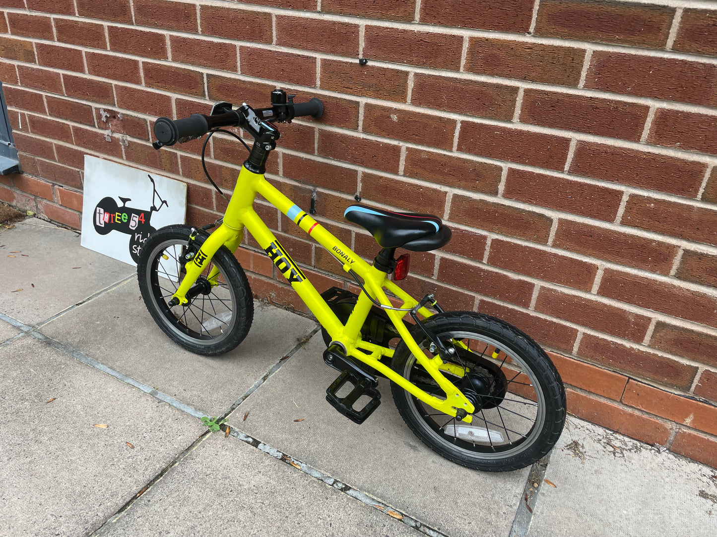 A Pre Loved Hoy Bonaly 14” first pedal bike For Sale, bright yellow, padded seat, V brakes, fully enclosed chain, nationwide delivery is available.