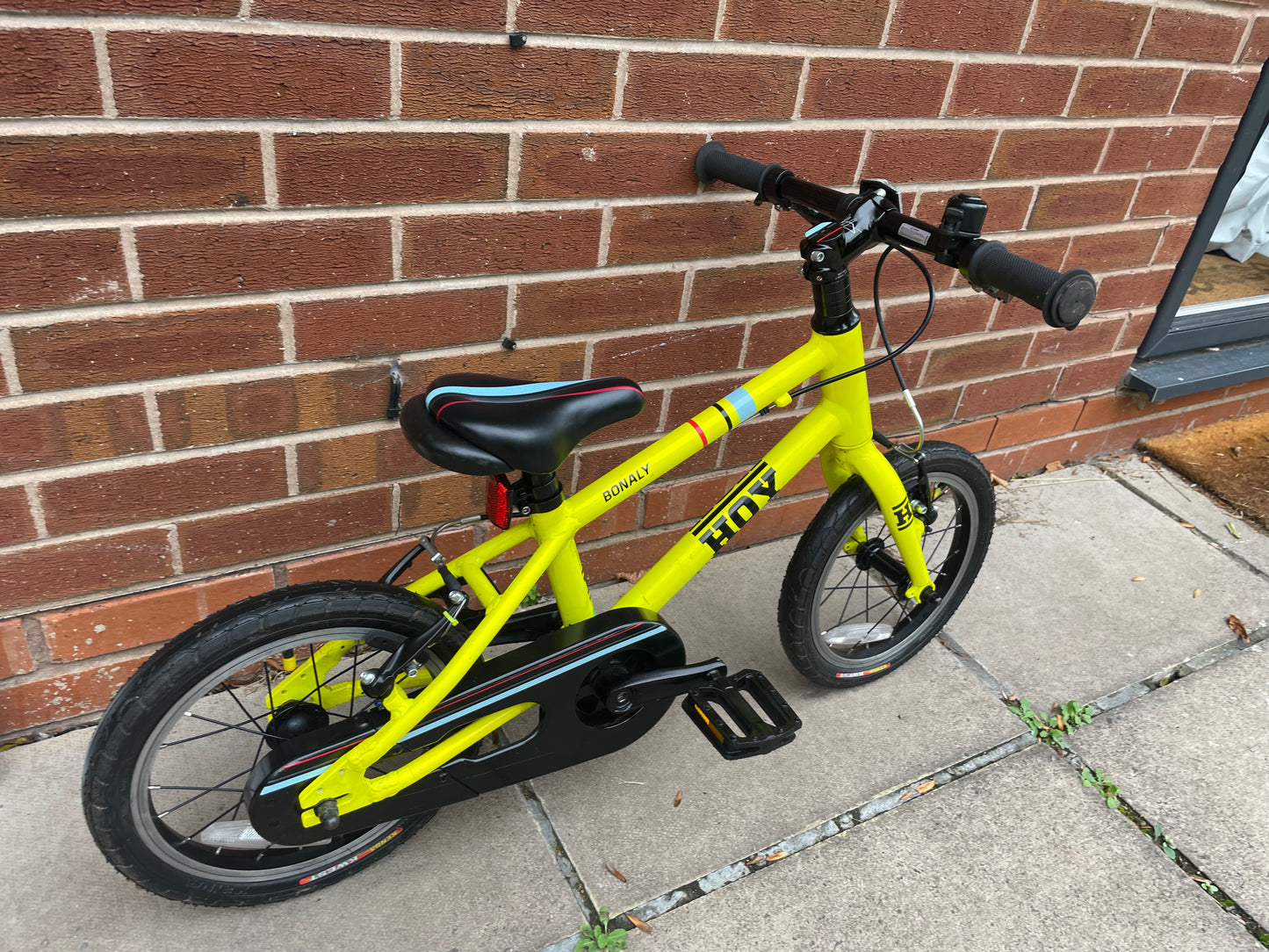 A Pre Loved Hoy Bonaly 14” first pedal bike For Sale, bright yellow, padded seat, V brakes, fully enclosed chain, nationwide delivery is available.